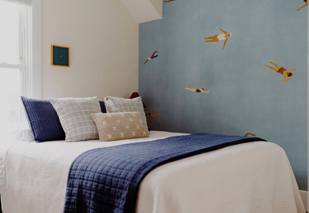 Guest Room with Wallpaper from Rebel Walls and a Bed with multiple pillows. Done in Lake Blues.