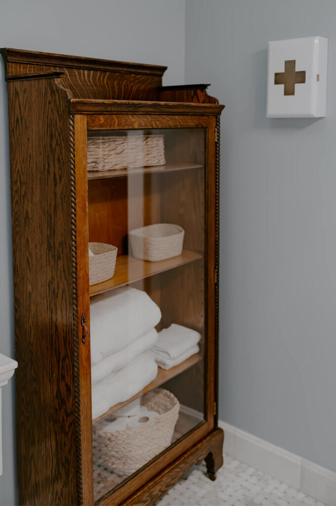 Vintage cabinet filled with towels and amenities for hosting overnight guests.