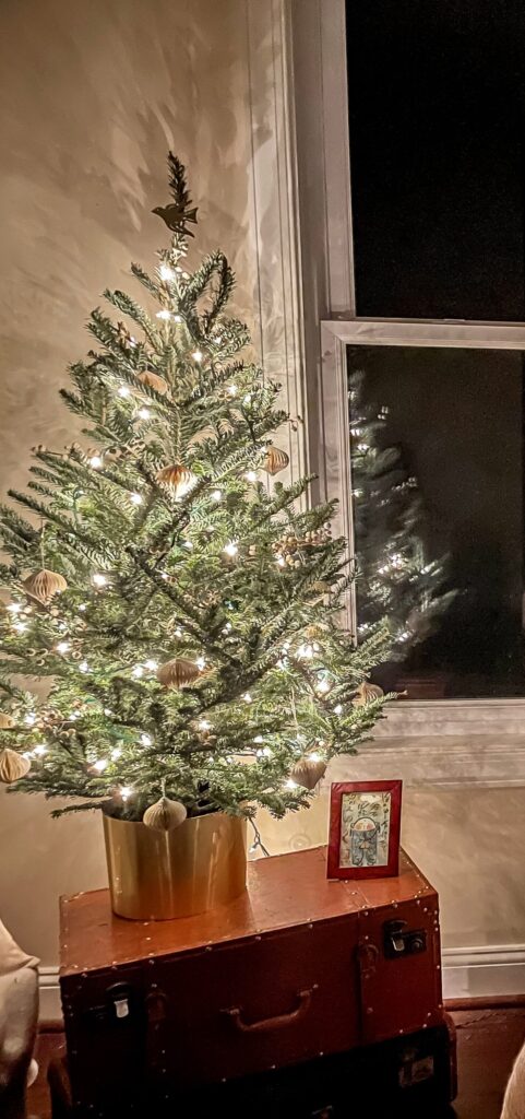 Tabletop Christmas Tree lit up in a Primary Bedroom.