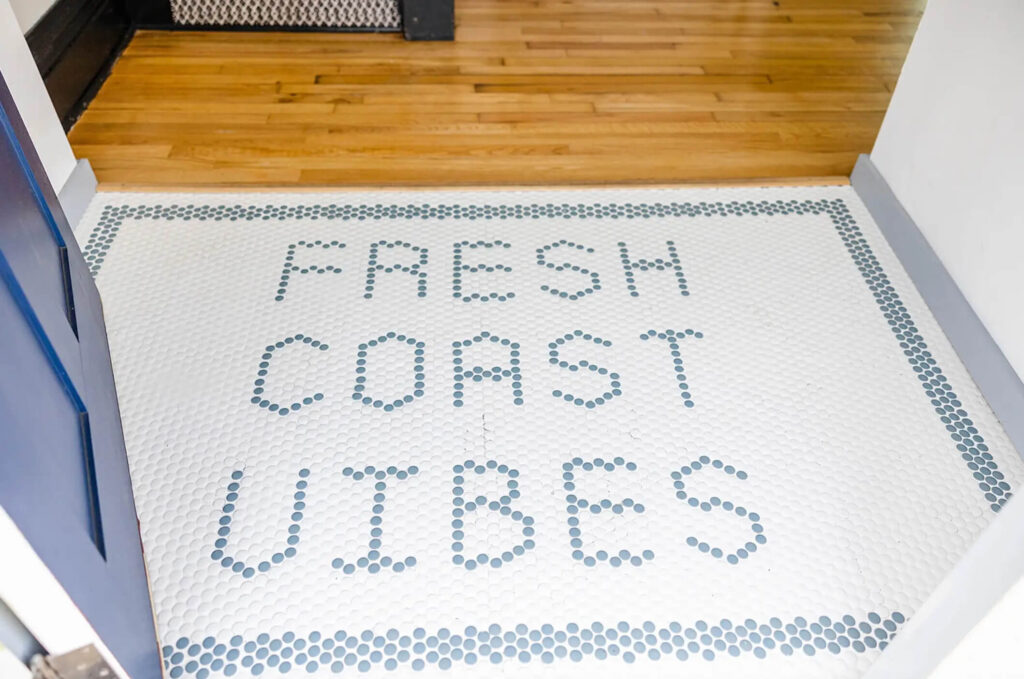 Fresh Coast Vibes are spelled out in Penny tile in a small entryway.