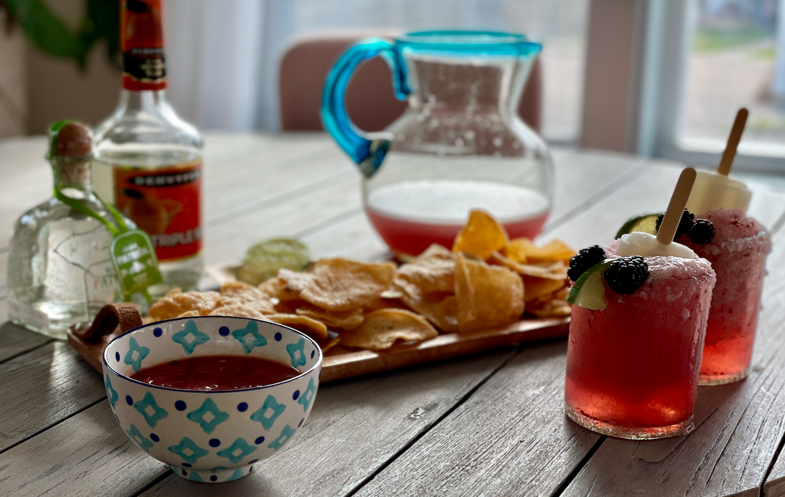 Frozen Blackberry-Lime Margarita's in a pitcher with chips and salsa