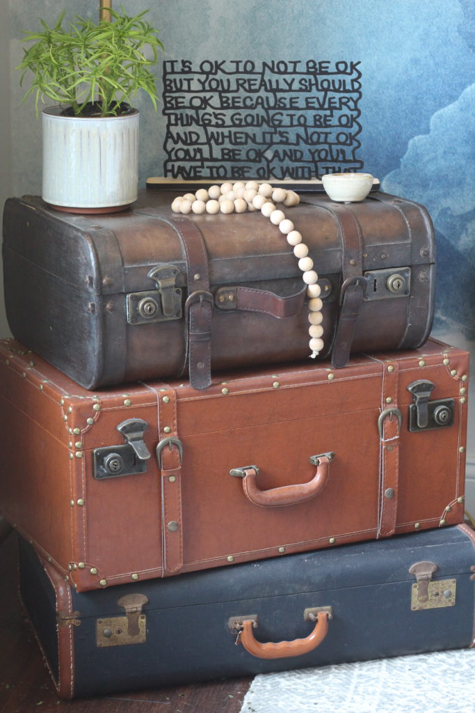 Vintage Suitcases shown in guest bedroom with wall mural in background.