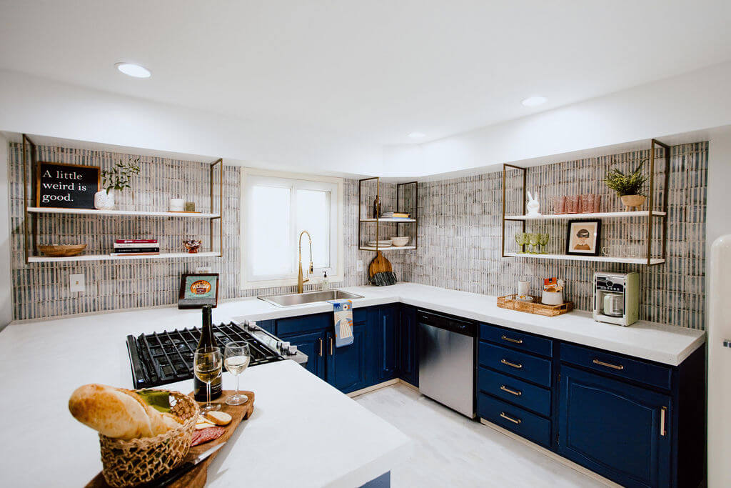 Modern Cottage Kitchen featuring white concrete countertops with Navy painted cabinets, blue and white striped wall tile and a SMEG refrigerator