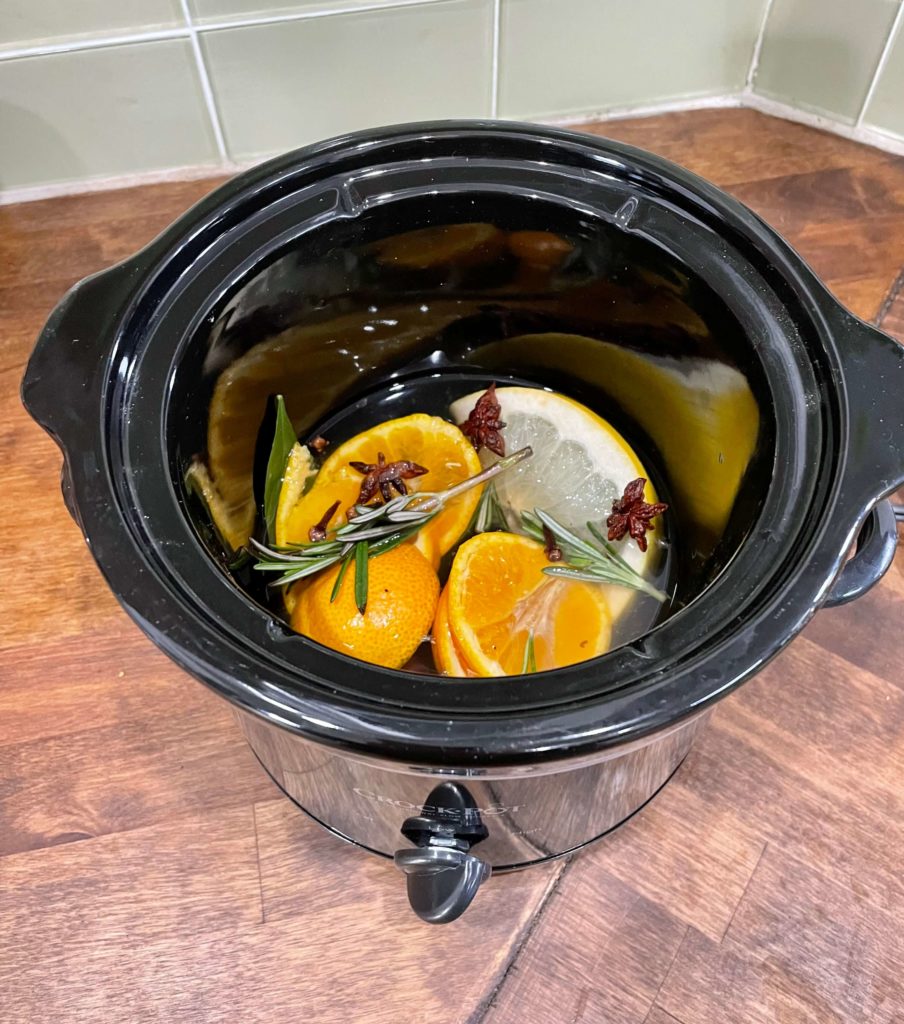 Simmering Christmas potpourri with oranges, rosemary, vanilla, star of anise, cloves and cinnamon sticks.