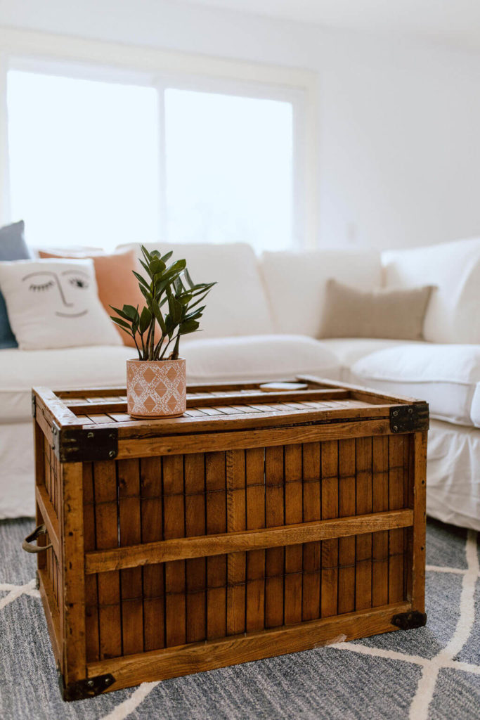 Antique crate as a coffee table with white sofa from Ikea.