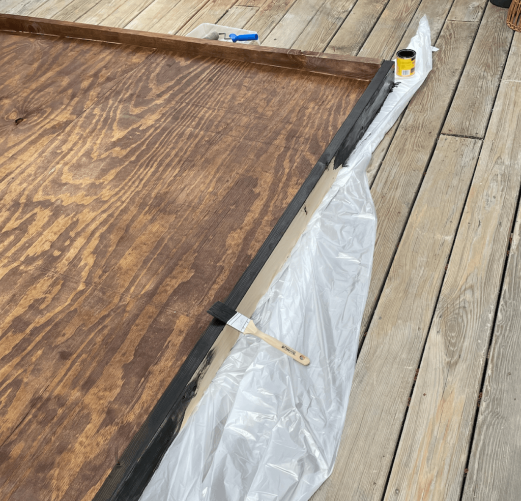 Staining the DIY outdoor living wall structure.