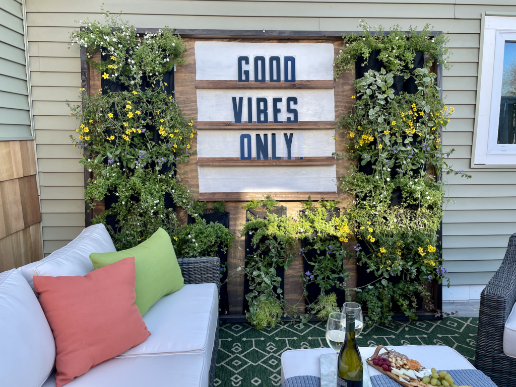 Outdoor living space with giant DIY letter board and living plant wall.