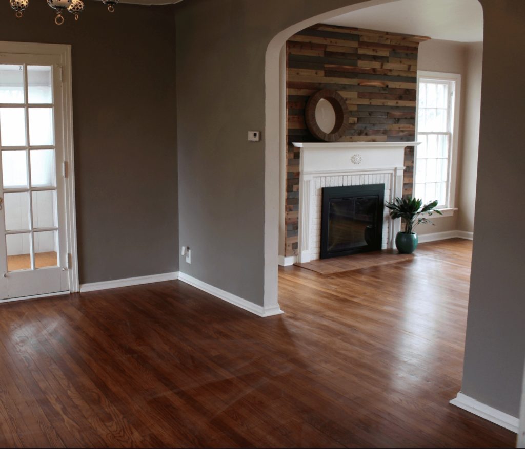 View from Gray Dining room into Living room with an updated wood plank fireplace.