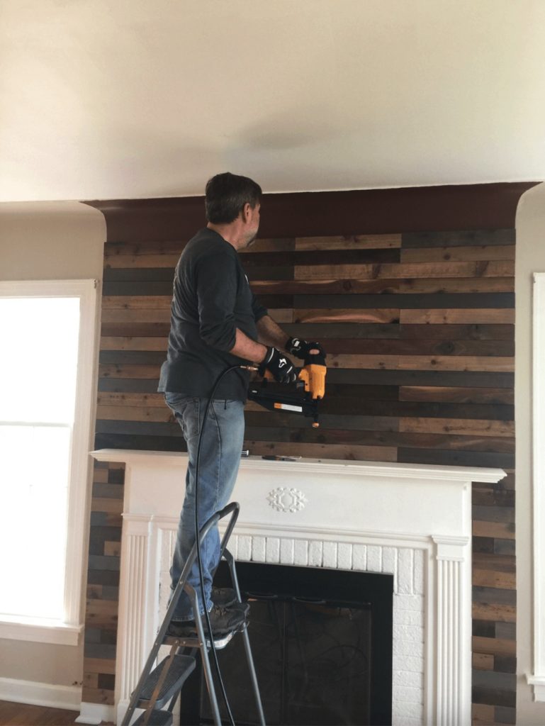 Showing installation of wood on a fireplace being updated.