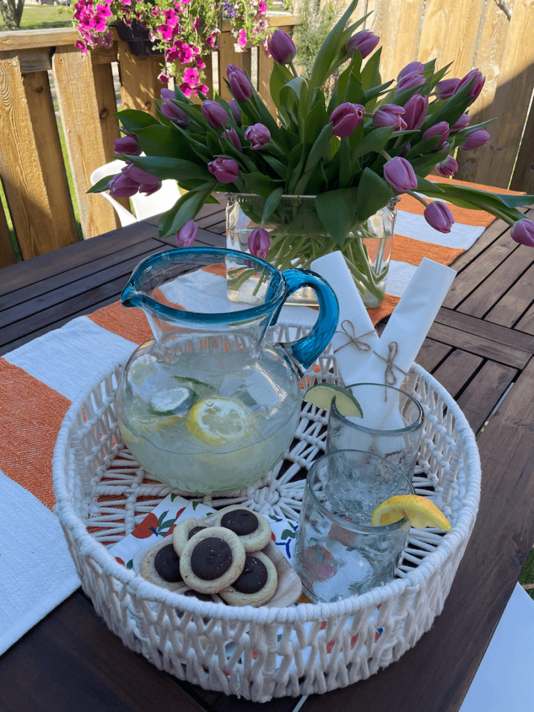 White tray with lemonade and cookies on a picnic table