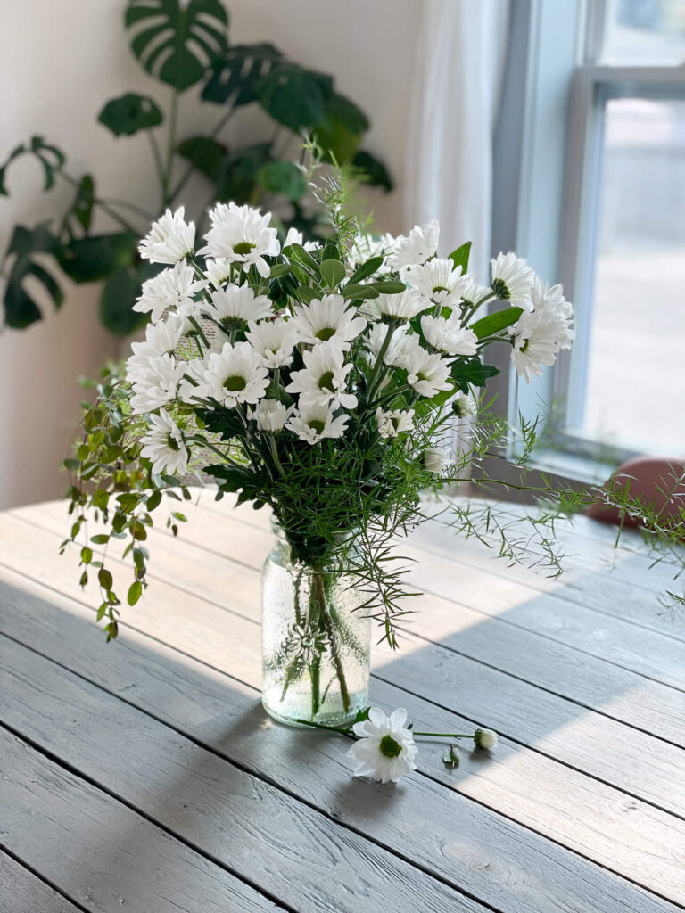 Vase of white daisies.