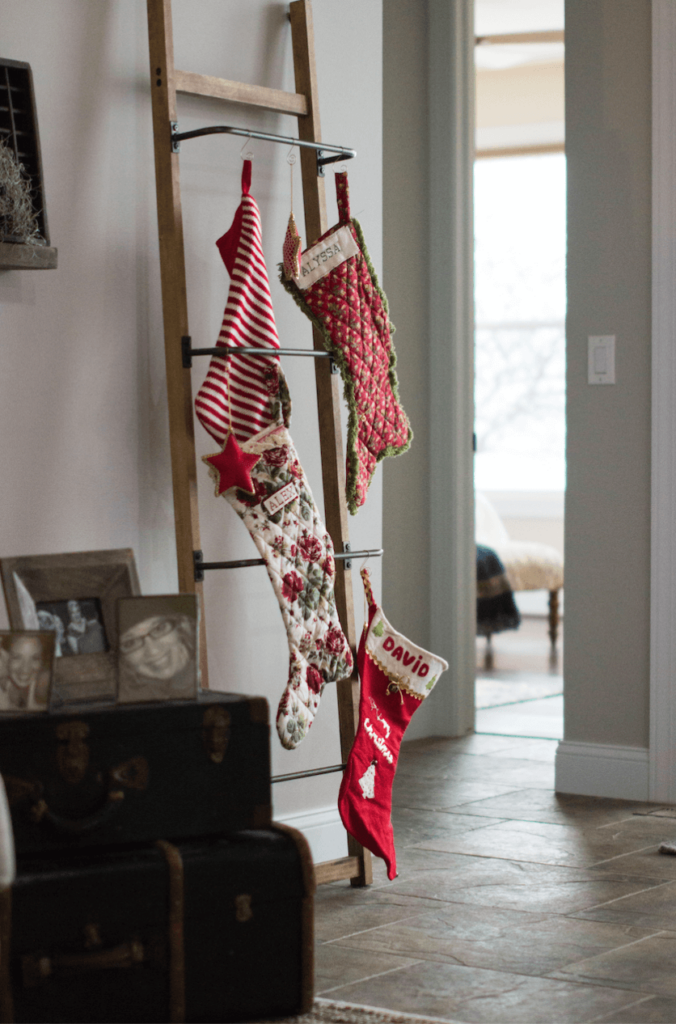 Christmas stocking hanging from a wooden ladder in a living room.