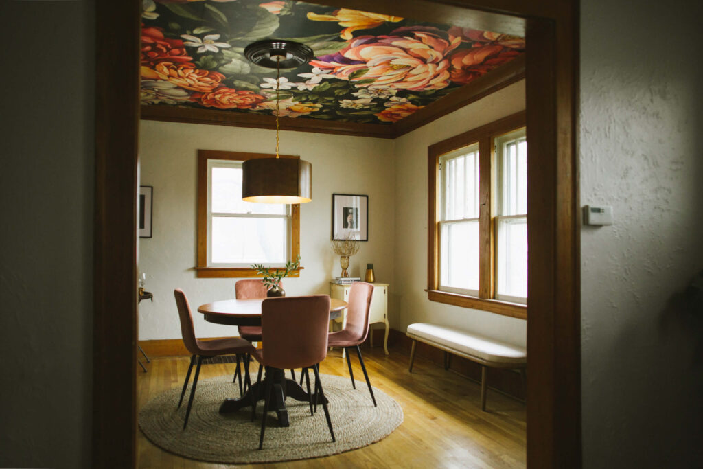 Dining room with dark floral wallpaper on the ceiling