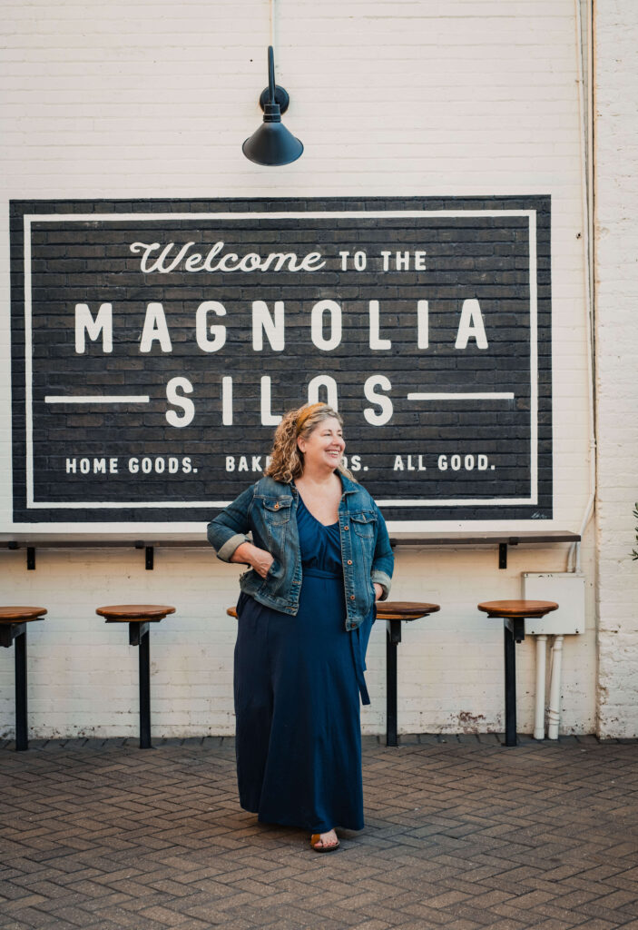 Woman walking in front of Magnolia Silos Sign