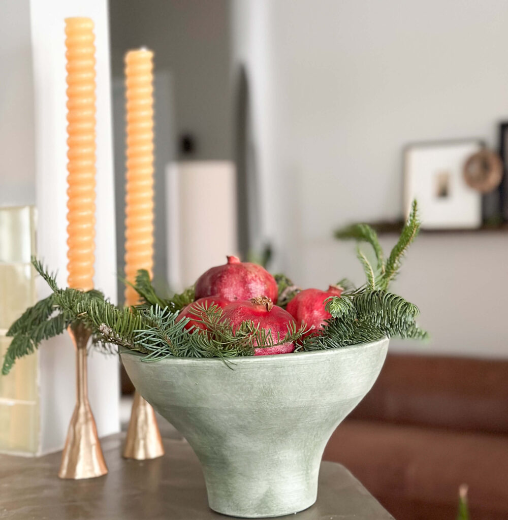 Bowl of Pomegranates and Christmas greens.