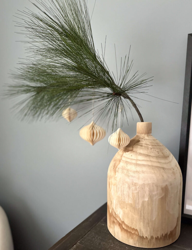 Greenery in wood vase with paper ornaments
