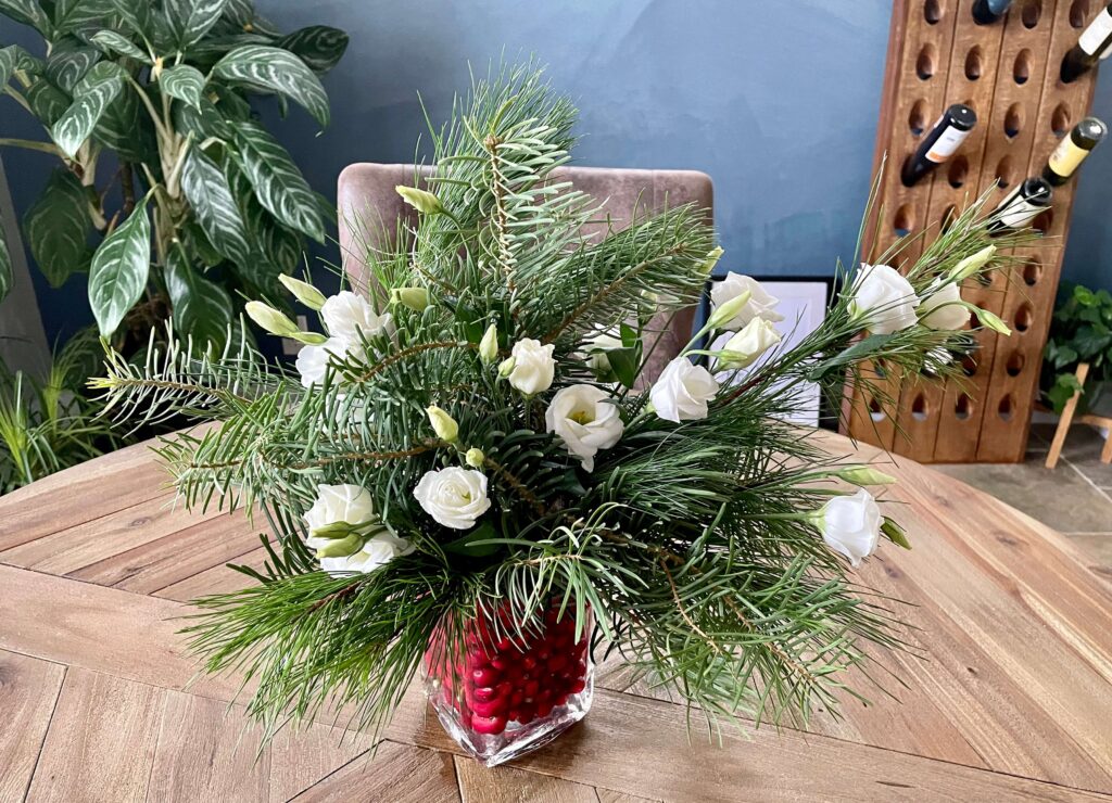 Vase of flowers and Christmas Greenery with fresh cranberries.