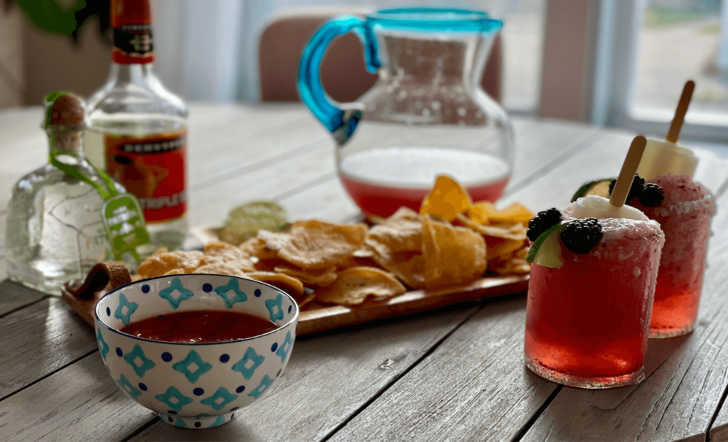 Chips, salsa and Frozen Blackberry-Lime Margaritas on a table.