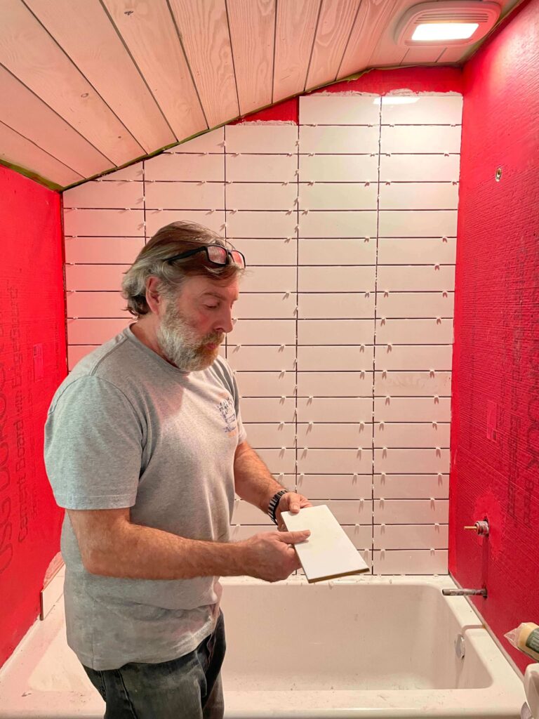 Tiling a small cottage bathroom with classic white subway tile in a stacked pattern.