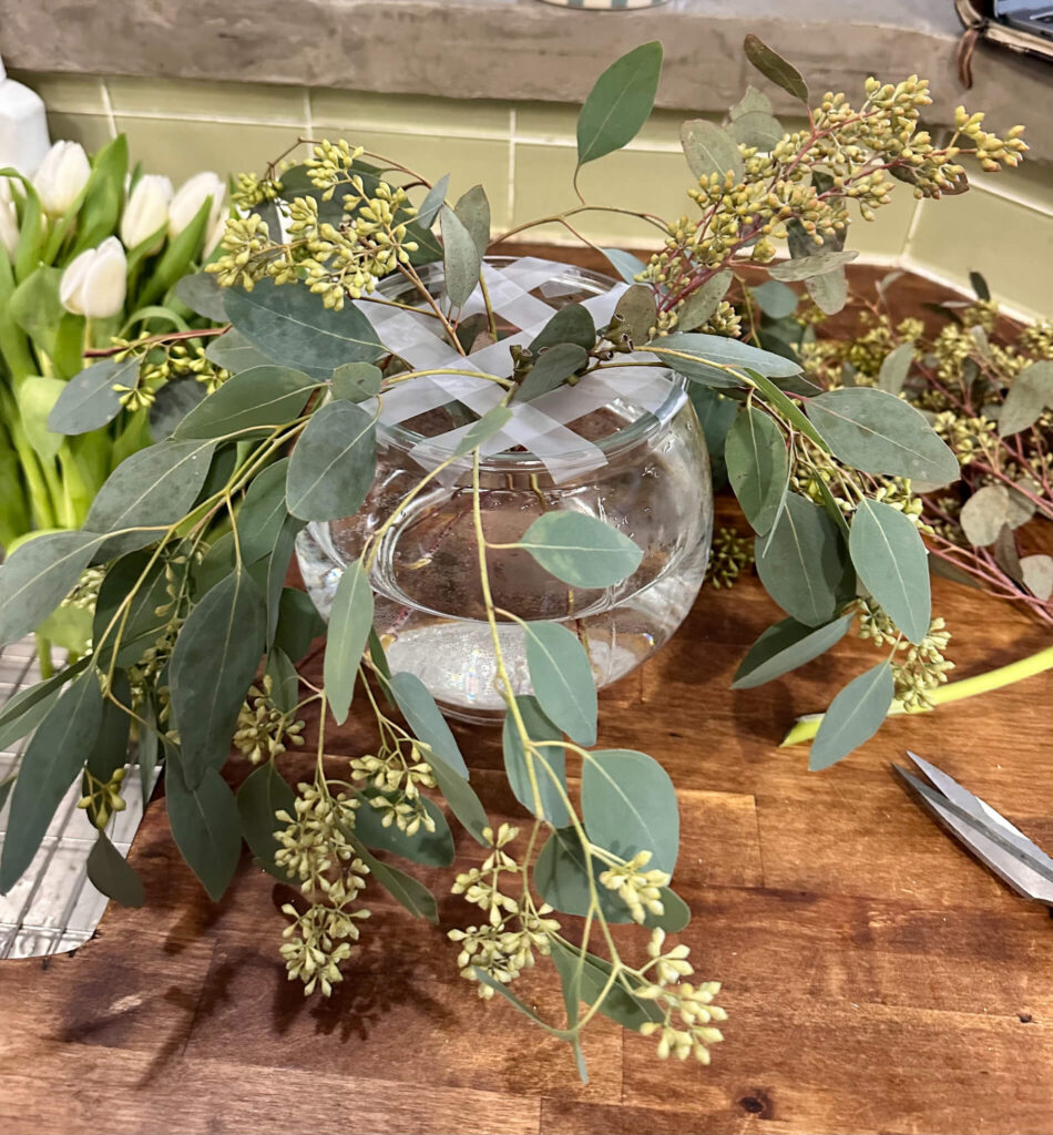 Seeded Eucalyptus being placed into a grid for a DIY romantic floral arrangement.