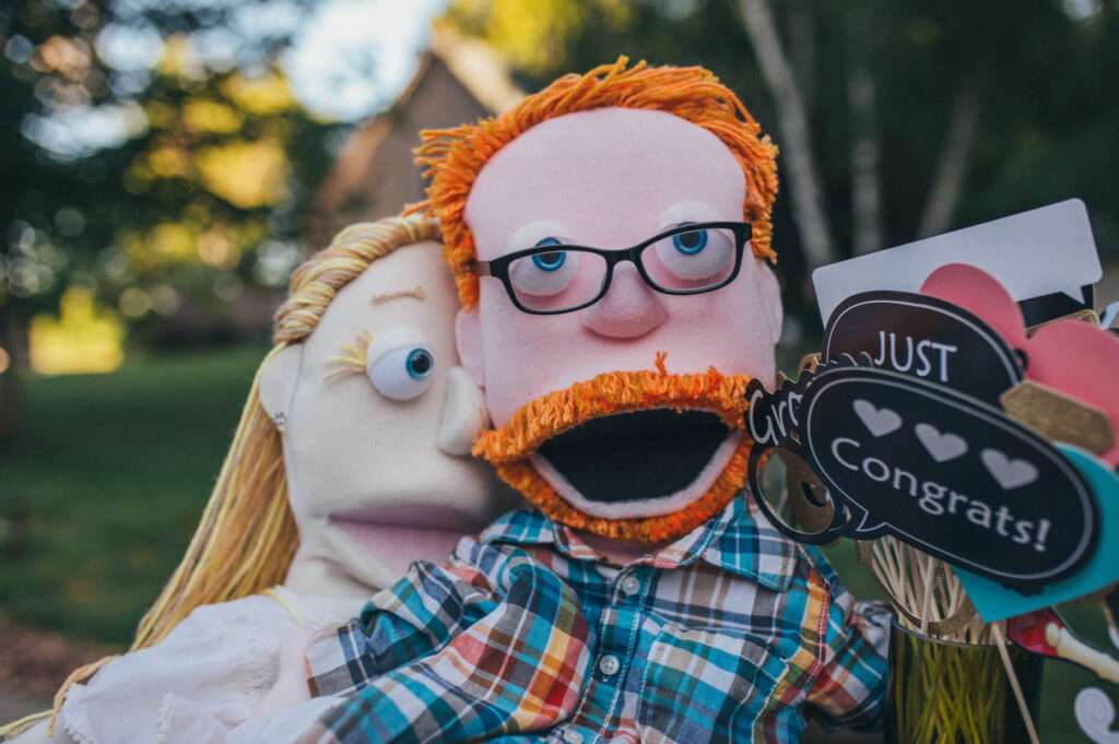 Bride and Groom Puppets as Photo Props at an Outdoor Lake House Wedding. 