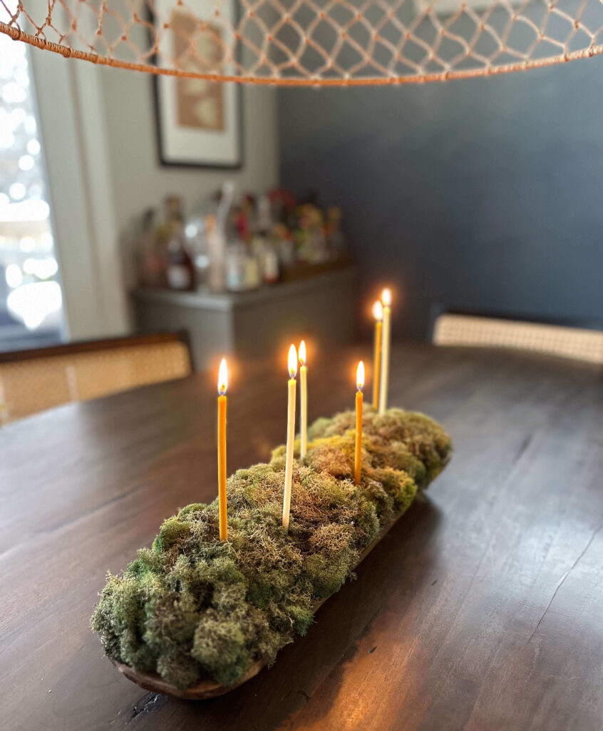 Centerpiece made with moss in a dough  bowl with candles.