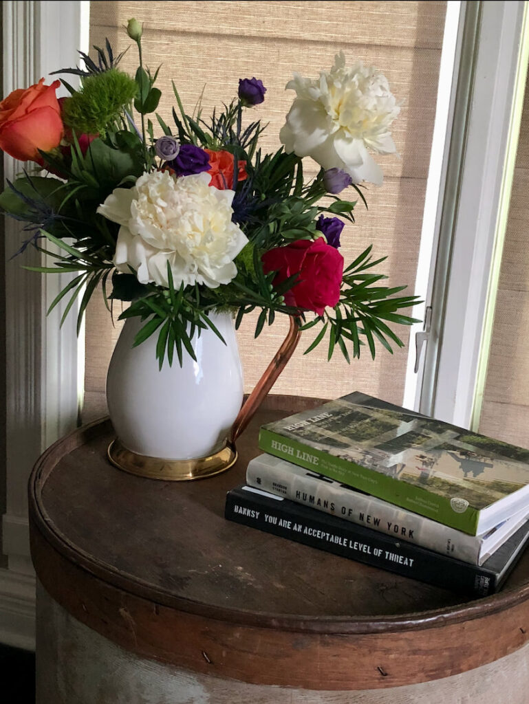 Beautiful flowers and books on a vintage end table.