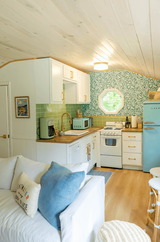 Small cottage kitchen with blue retro fridge and butcher block counters.
