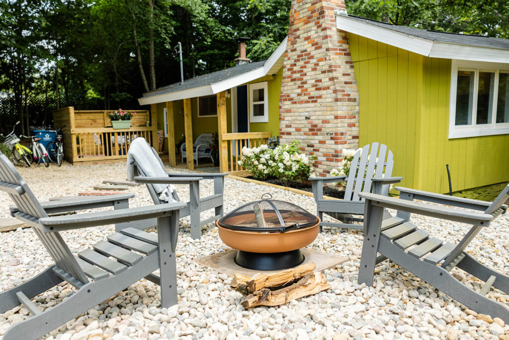 Green Cottage with a fire pit. Landscaped with low-maintenance rocks.