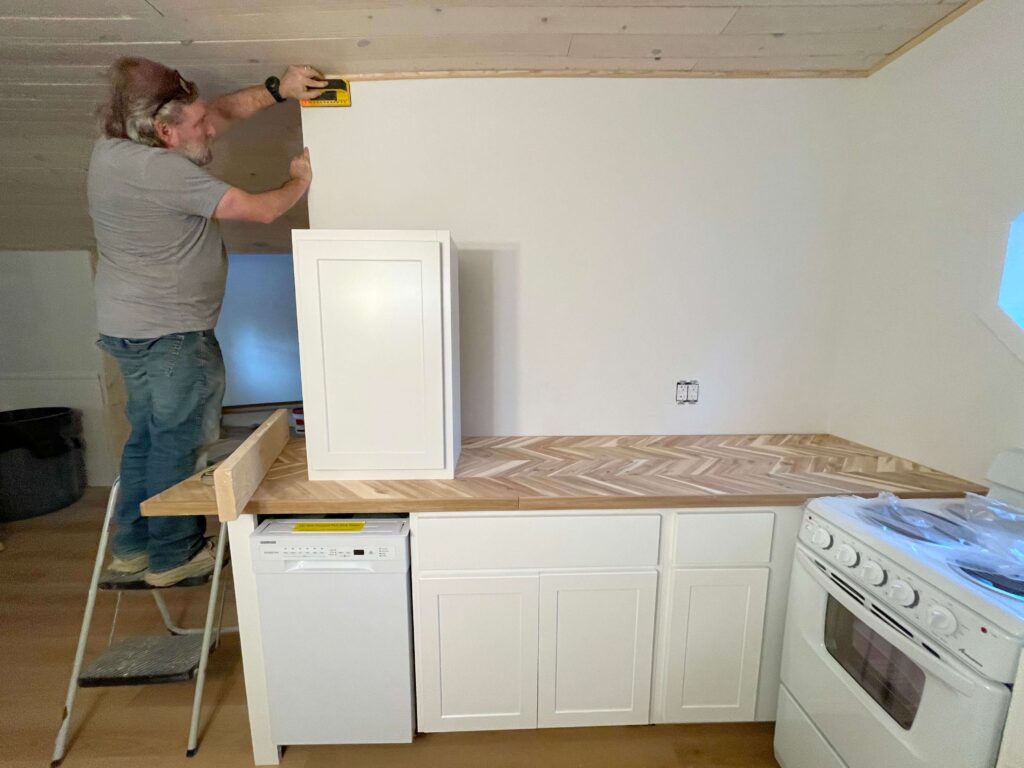 Hanging kitchen cabinets in a small cottage kitchen #cottagerenovation #cozykitchen 