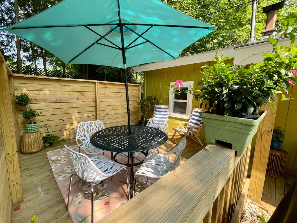 Small deck with table and chairs decorated for summer.