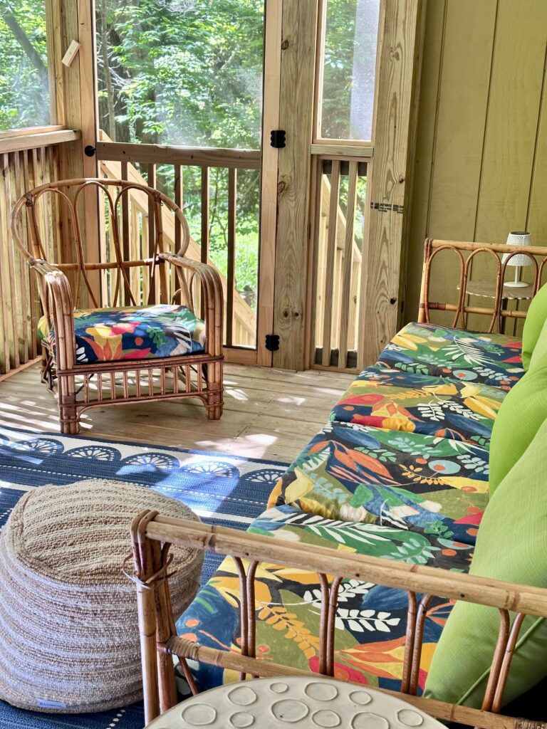 Vintage outdoor furniture on a screened in cottage porch.