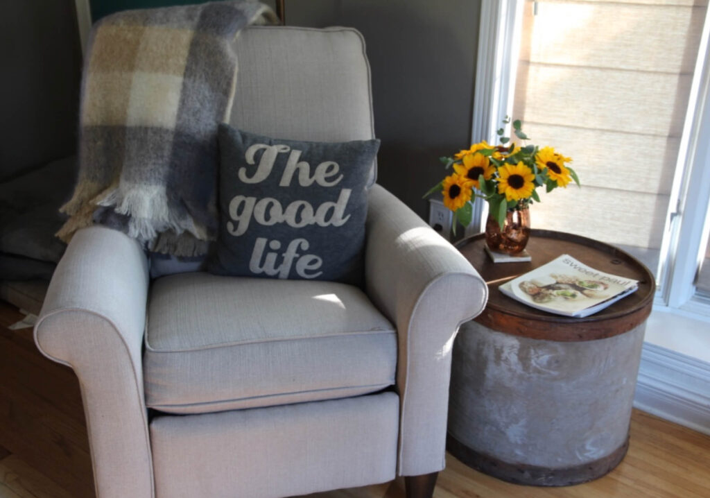 Chair with a pillow that reads A Good Life and Fall Decor