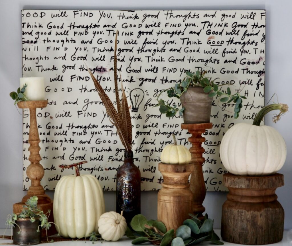 Candle holder holding mini pumpkins and succulents for a Fall display.