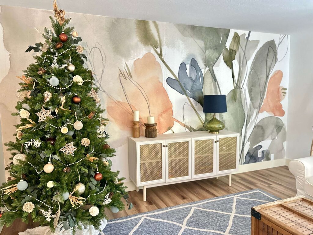 Living Room With a Bold Floral Wall Mural. Featuring a Decorated King of Christmas Tree.