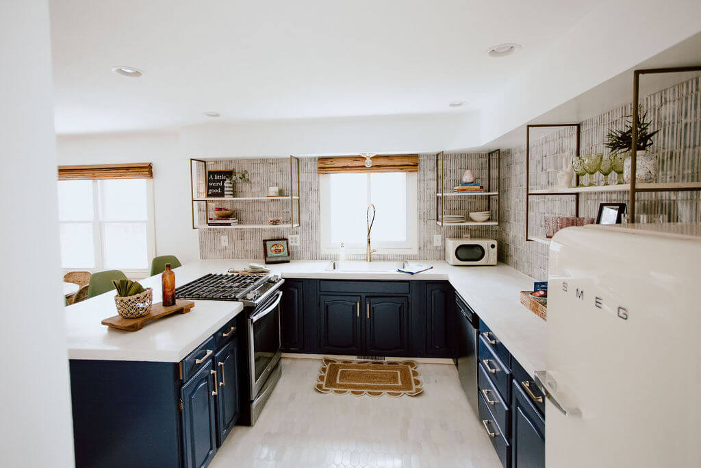 Modern Cottage Kitchen with open shelving, white concrete countertops, cream colored Smeg fridge and marine blue kitchen cabinets.