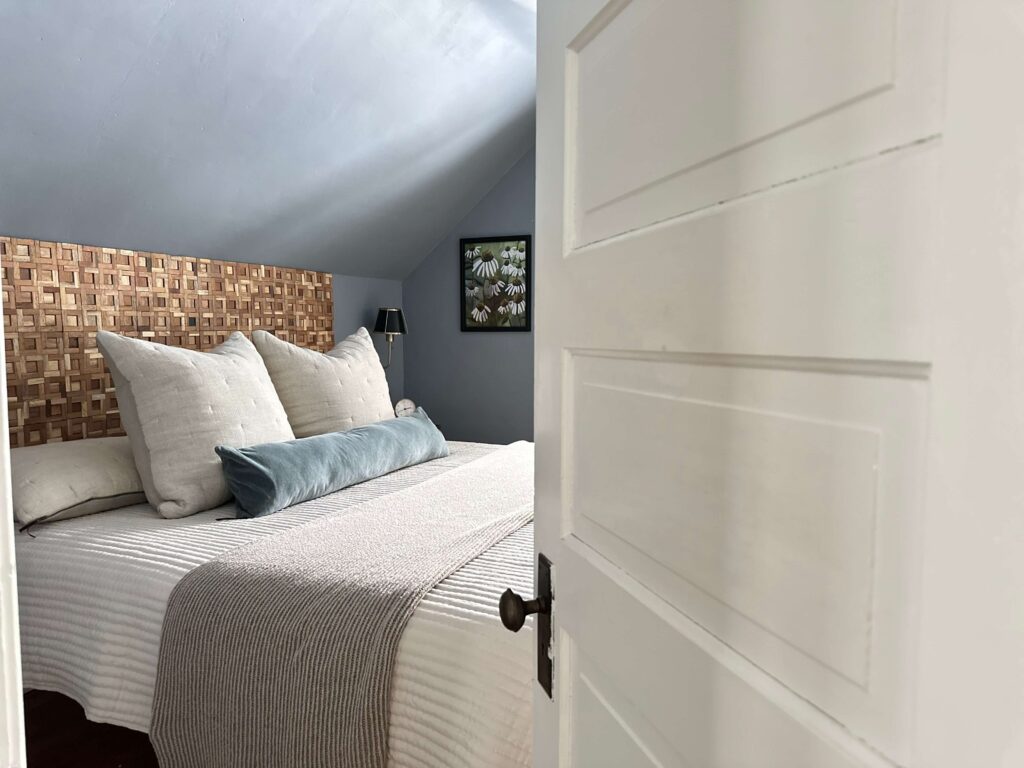 Bedroom with warm woods and blue grey walls.