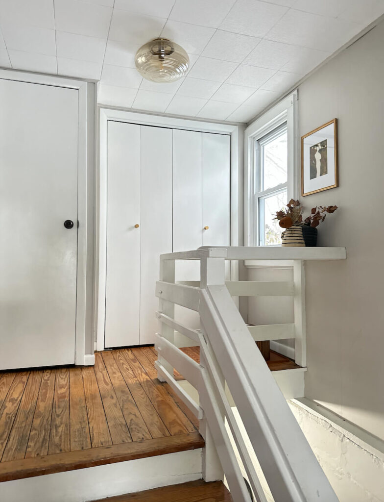 White entrway doors prior to a glow up with SW Rock Bottom.