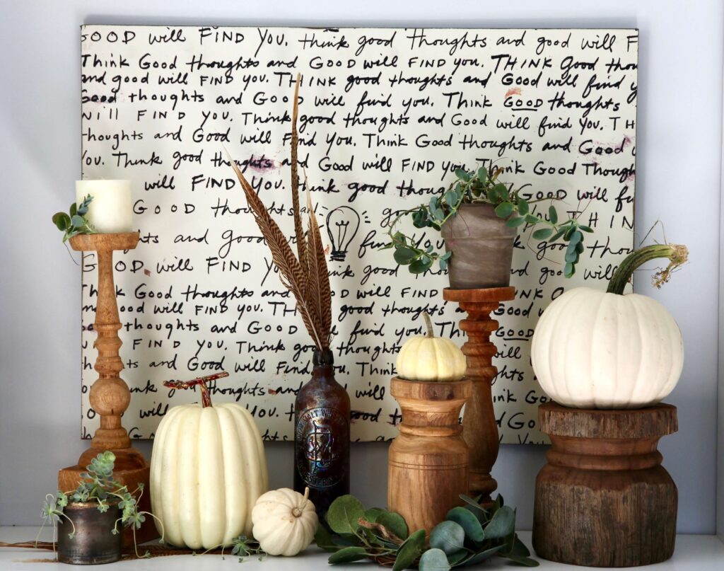 Fall decor with pumpkins, feathers, succulents and wood candlesticks.