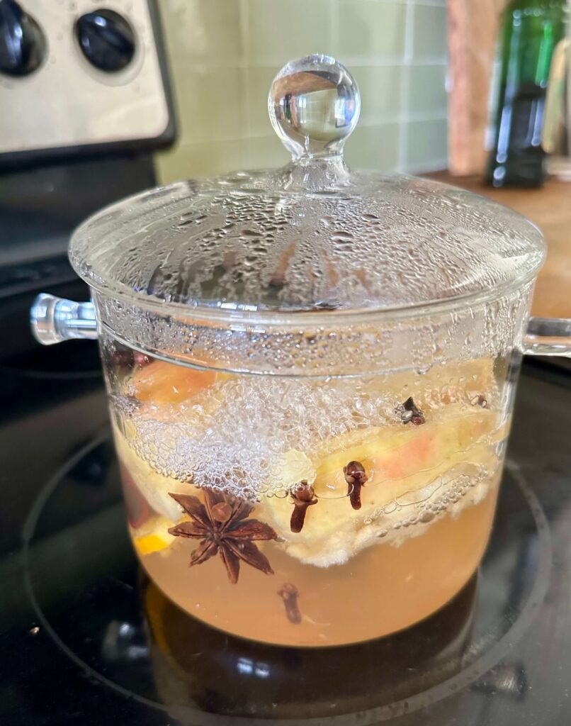 Fall Simmer Pot in a glass pot on the stove.