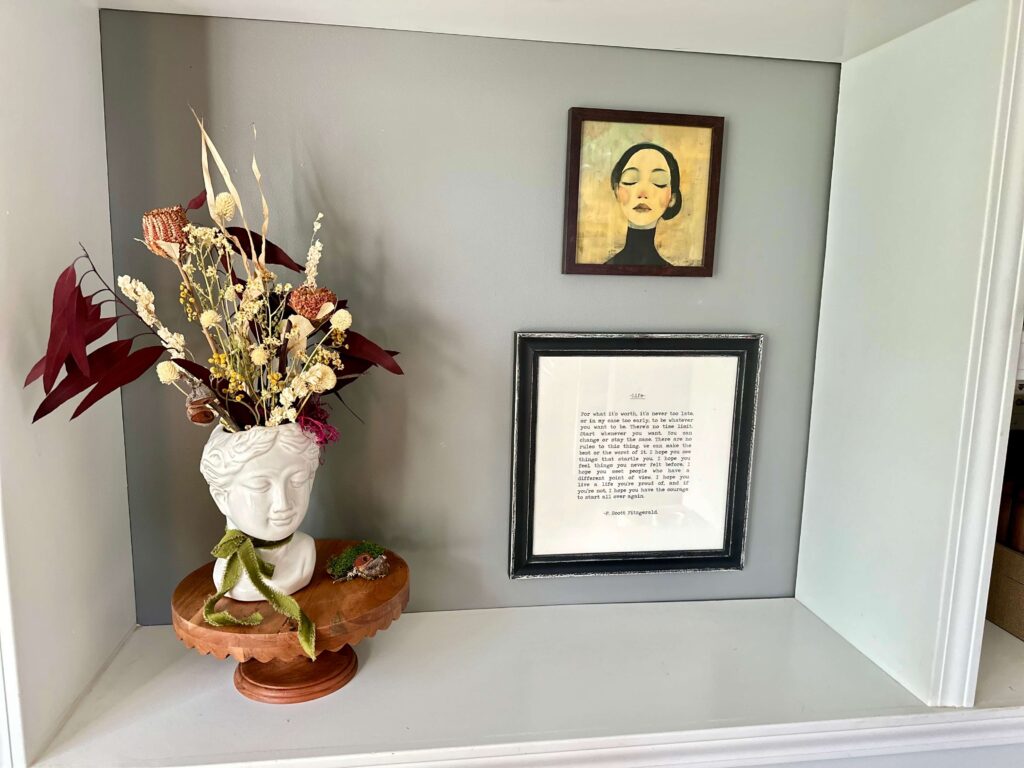 Vase with dried florals and wall Art on a bookcase