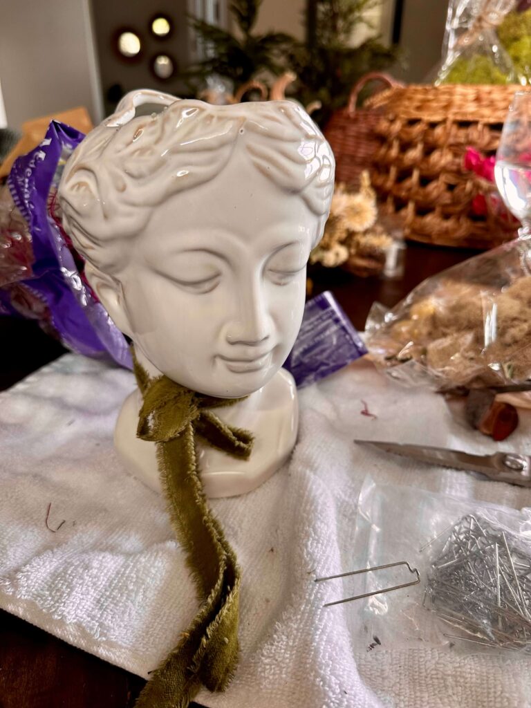 DIY Fall Dried Flower arrangement using a Lady Head Vase with a Green ribbon tied around her neck.