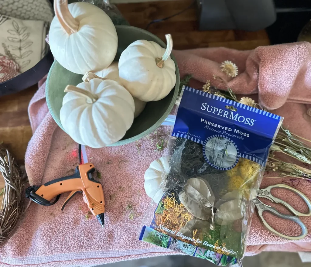 White mini pumpkins in a bowl getting ready to be made into place cards for a Friendsgiving Brunch.