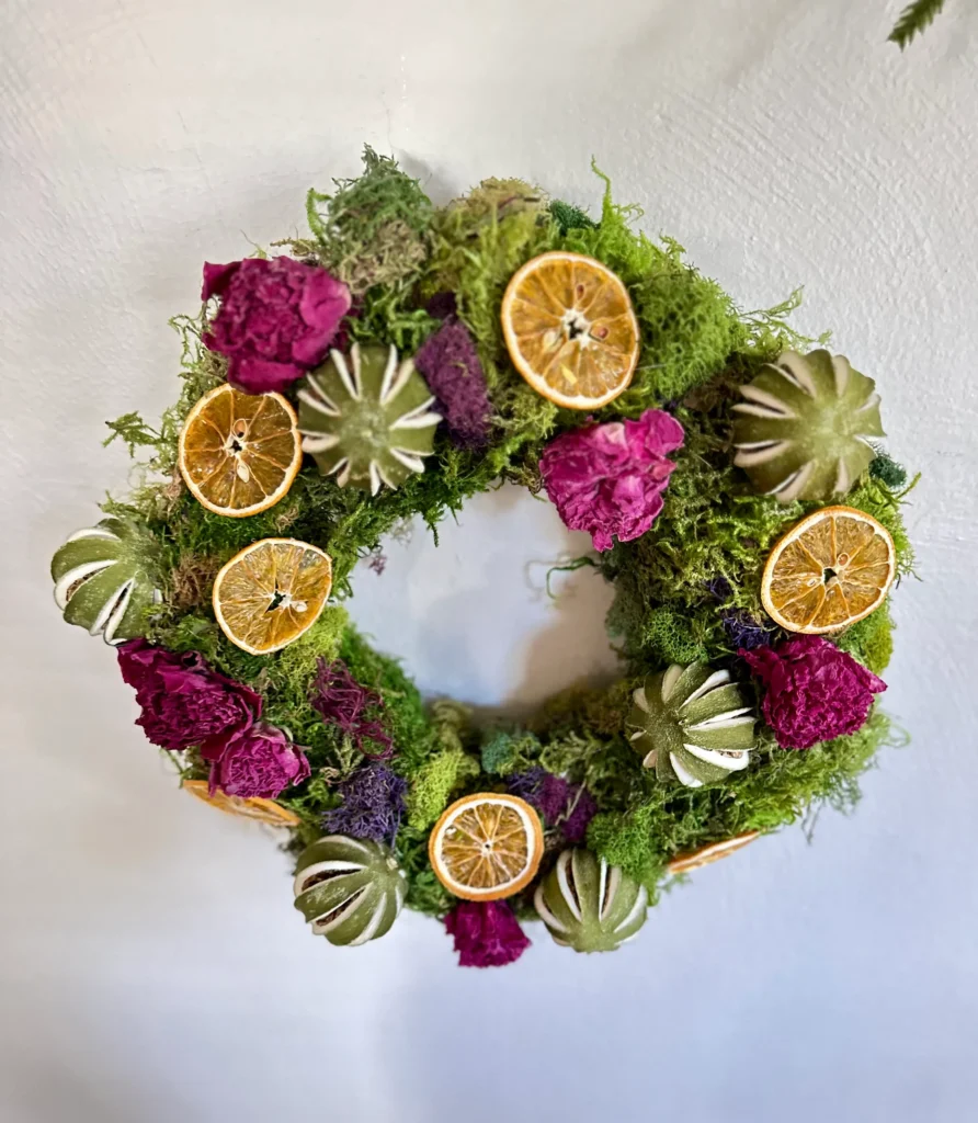 Christmas Wreath with moss, limes, oranges and peonies.