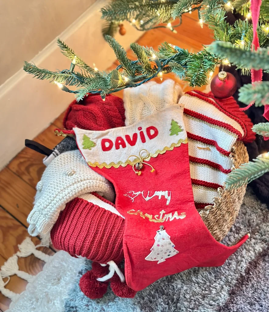 Stockings in a vintage basket next to Christmas Tree