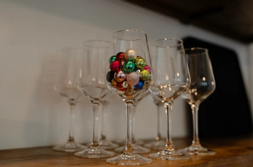 Wine glass filled with mini ornaments.