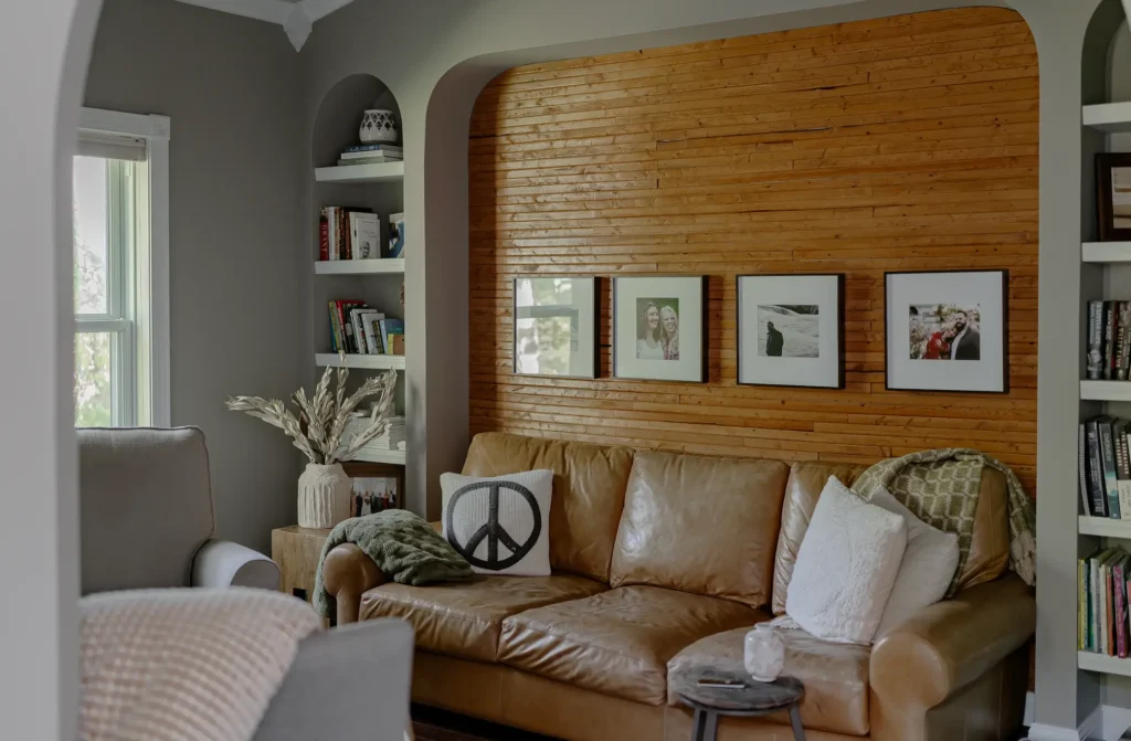 Camel Colored sofa next to a wood planked wall.
