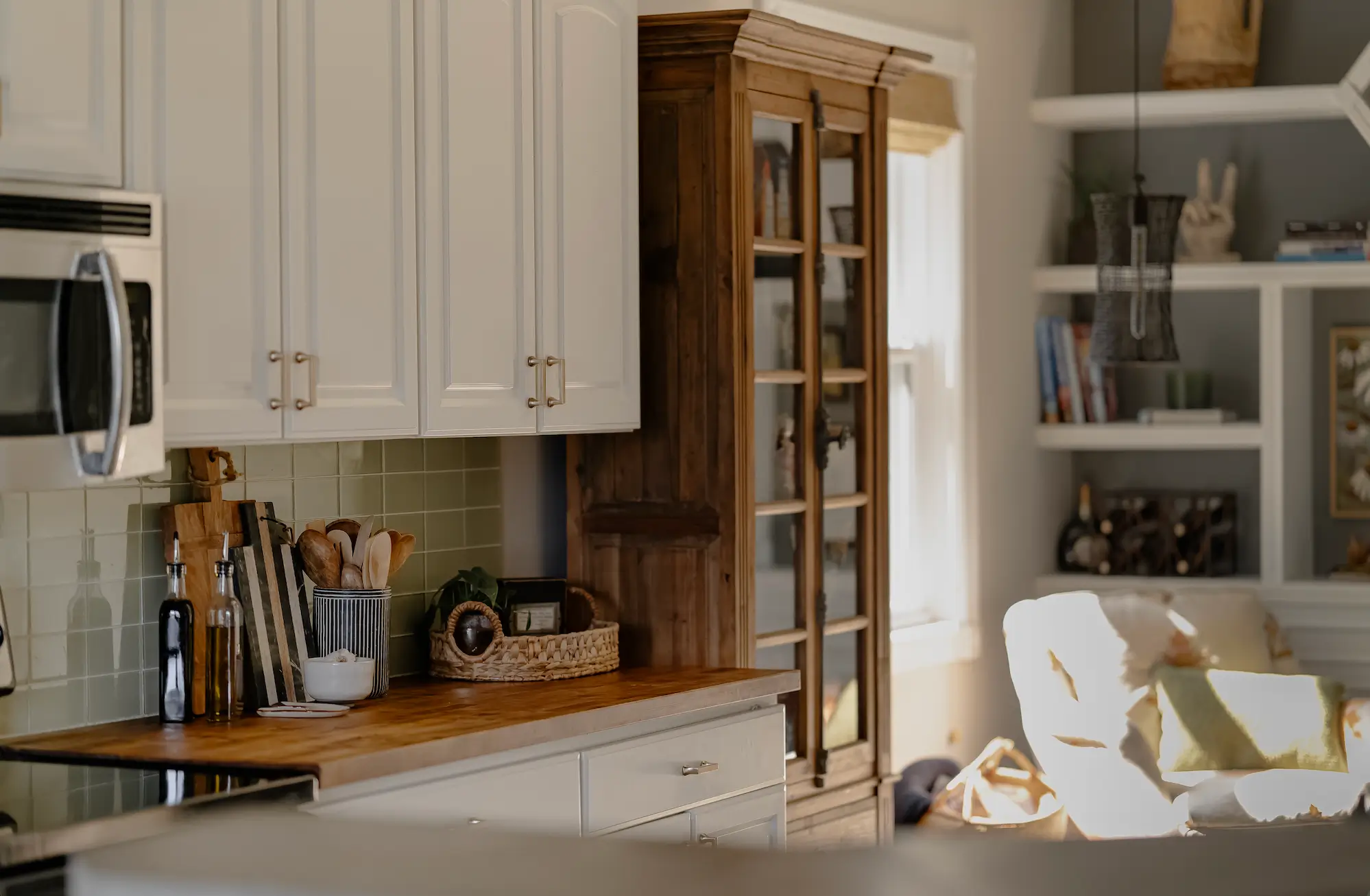 White Kitchen Cabinets with Wood Cabinet Pantry for warmth.