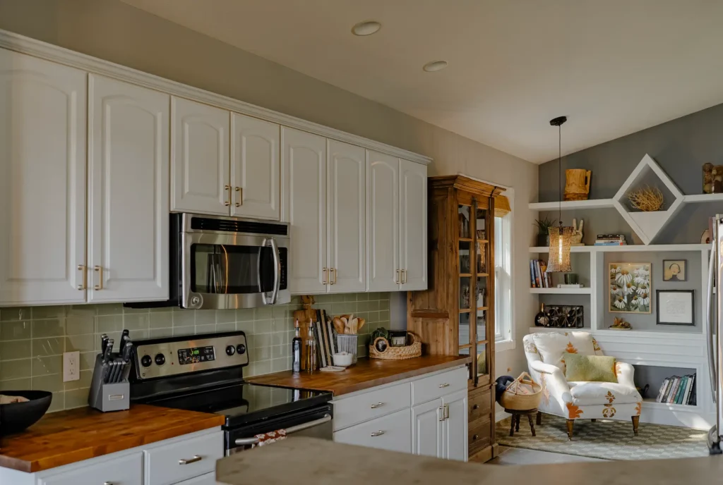A Wood pantry cabinet added to the end of white kitchen cabinets to add warmth.