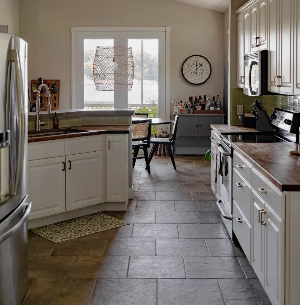 Wood pantry cabinet added to the end of white kitchen cabinets to add warmth.